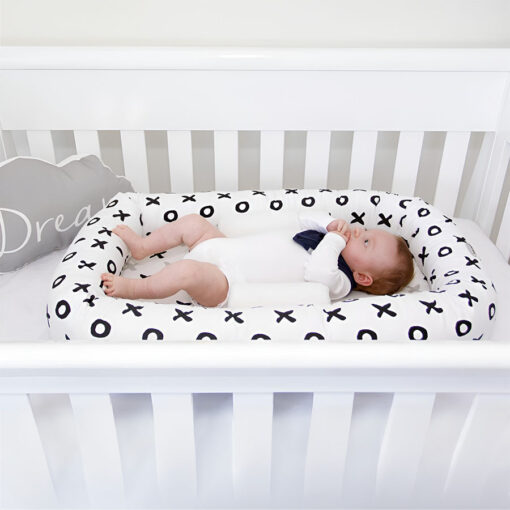 breathe eze sleep positioner supporting baby in cosy crib in cot